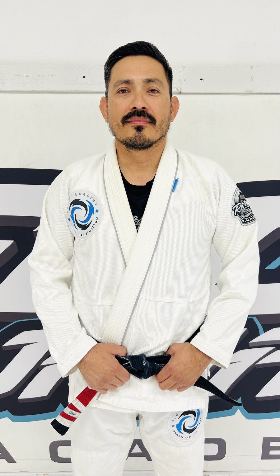 Professor Albert Aguirre, 2nd-degree black belt, in a white Flow Academy gi